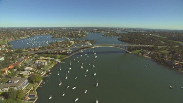 Gladesville Bridge, marina with yachts. Harbour with luxury mansion homes with waterfront access. Yachts and boats.
