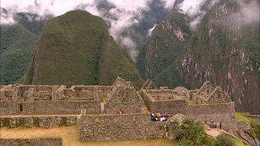 The ruins of Machu Picchu with cloud covered mountains in the back ground