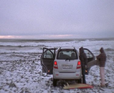 Car Being Unpacked For A Surf Session On Snow Covered Beach