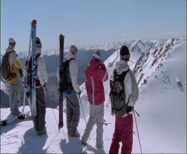 Shot Of skiers And Snowboarders Looking Out At Snowy Mountains