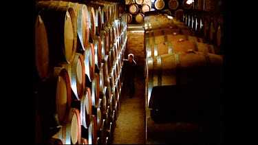 High Angle. Vintner checks wine fermenting in barrels. Wine cask inspection.