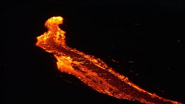 Volcano erupting. Very wide lava river flow coursing down channel