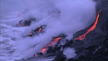 Lava flowing directly into ocean. Waves turning to steam.