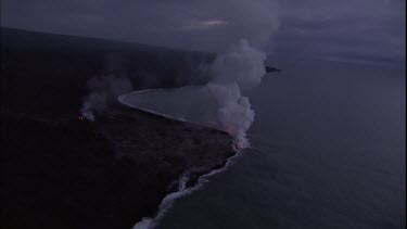 Where the edge of the Kilauea lava delta meets the ocean a line of steam rises into the air. Lava being washed out to sea.