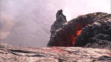 Lava erupting and splashing out of vent / hole in lava field.