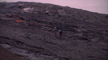 Scientists walking over lava field