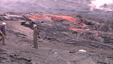 Scientists walking over lava field