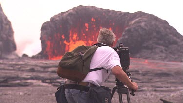Filmmaker , cameraman filming volcano erupting