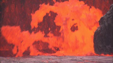 Lava erupting from vent pull back to reveal cameraman filming eruption