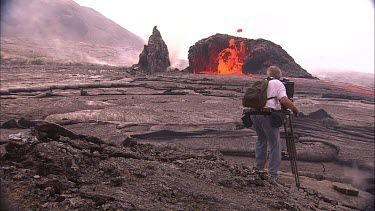 Lava erupting from vent pull zoom in cameraman filming eruption