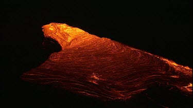 Incandescent lava erupting out of a fissure. Night.