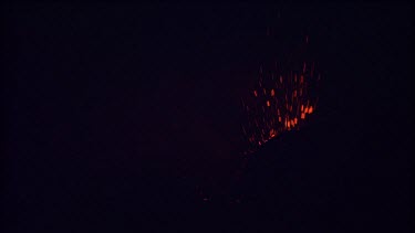 Lava sputtering and erupting out of a vent. Volcanic eruption. Night