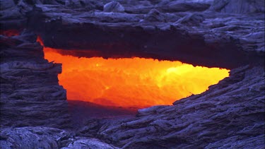 Looking into a lava tube or a fissure, as if looking into the surface of the earth and seeing the magma, incandescent and alive.