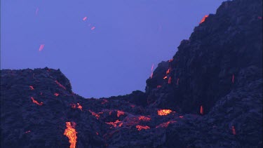Lava sputtering and erupting out of a vent. Volcanic eruption. Smokey eerie landscape