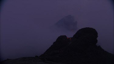 Lava sputtering and erupting out of a vent. Volcanic eruption. Smokey eerie landscape
