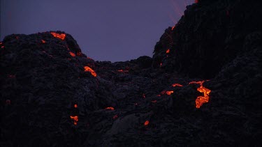 Lava sputtering and erupting out of a vent. Volcanic eruption. Smokey eerie landscape