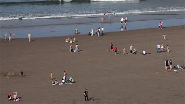 People Playing In Sea & On Beach, Whitby, North Yorkshire, England